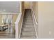 Carpeted staircase with white railing leads to the upper level of the house, with adjacent living room with wood floors and lots of light at 1004 Bridgewater Dr, Durham, NC 27704
