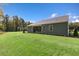 Expansive green backyard featuring lush grass, mature trees, and covered patio at 1008 Octans Way, Wendell, NC 27591
