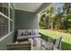 Covered patio with comfortable seating overlooking the well-maintained backyard and greenery at 1008 Octans Way, Wendell, NC 27591
