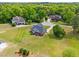 Aerial view of brick home with dark roof on a large lot landscaped with green trees and a long driveway at 105 Pinecrest Dr, Angier, NC 27501