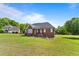 Brick house with a covered back porch and large grassy yard at 105 Pinecrest Dr, Angier, NC 27501