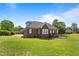 Large backyard with a well-manicured lawn, brick house, and mature trees at 105 Pinecrest Dr, Angier, NC 27501
