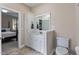 Bathroom with white cabinets, mirror, and neutral wall color, next to a bedroom at 105 Pinecrest Dr, Angier, NC 27501