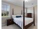 Bedroom featuring a four-poster bed, two dressers, carpet, and two windows at 105 Pinecrest Dr, Angier, NC 27501