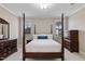 Cozy primary bedroom with a four-poster bed, two dressers, and windows at 105 Pinecrest Dr, Angier, NC 27501