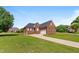 Beautiful all-brick home with a well-maintained lawn and a long driveway leading to the garage at 105 Pinecrest Dr, Angier, NC 27501