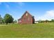 Brick house with manicured lawn and mature trees on a sunny day at 105 Pinecrest Dr, Angier, NC 27501