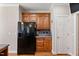 Kitchen with black refrigerator, granite countertops, and wood cabinets next to a door at 105 Pinecrest Dr, Angier, NC 27501