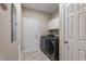Laundry room with washer, dryer, storage cabinets and back door to the outside at 105 Pinecrest Dr, Angier, NC 27501