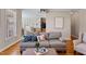 Bright living room with gray sofa, ottoman, and view into the dining area and kitchen at 105 Pinecrest Dr, Angier, NC 27501