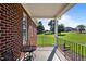 Relaxing covered porch features an iron railing and a view of the well-manicured lawn at 105 Pinecrest Dr, Angier, NC 27501