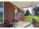 Relaxing covered porch features an iron railing and view of the manicured lawn at 105 Pinecrest Dr, Angier, NC 27501