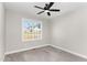 Bright, carpeted bedroom with a ceiling fan and large window offering natural light and outdoor views at 110 Lilac Dr, Franklinton, NC 27525