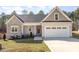 Charming home with a stone facade, a welcoming front porch, and an attached two car garage at 110 Lilac Dr, Franklinton, NC 27525