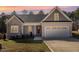 Charming home with a stone facade, a welcoming front porch, and an attached two car garage at 110 Lilac Dr, Franklinton, NC 27525
