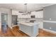 Bright kitchen with a center island, white cabinets, and a view into an adjacent room at 110 Lilac Dr, Franklinton, NC 27525