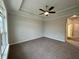 Empty bedroom features carpet, ceiling fan, tray ceilings with crown molding, and large bright window at 1113 Hudson Dr, Mebane, NC 27302