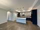 Open kitchen view features an island with pendant lighting, stainless appliances, and hardwood flooring at 1113 Hudson Dr, Mebane, NC 27302