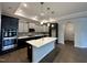 Modern kitchen boasts stainless steel appliances, center island with a marble countertop, and dark hardwood floors at 1113 Hudson Dr, Mebane, NC 27302