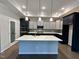 Spacious kitchen with two-tone cabinets, stainless steel appliances, large island, and pendant lighting at 1113 Hudson Dr, Mebane, NC 27302