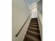 Carpeted staircase featuring a wooden handrail and neutral paint at 1113 Hudson Dr, Mebane, NC 27302