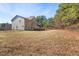 View of the backyard with a fenced in area and natural landscaping at 1175 Faulkner Town Rd, Henderson, NC 27537