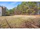 Large backyard with an expansive grassy area, partially fenced in with mature trees offering privacy at 1175 Faulkner Town Rd, Henderson, NC 27537