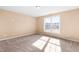 Bright, empty bedroom bathed in sunlight with neutral carpet and a large window overlooking an expansive lawn at 1175 Faulkner Town Rd, Henderson, NC 27537