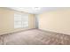 Bedroom with neutral walls, carpet, a window with blinds, ceiling light and a closed door at 1175 Faulkner Town Rd, Henderson, NC 27537
