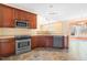 Updated kitchen features stainless steel appliances, wooden cabinets, and tiled floors at 1175 Faulkner Town Rd, Henderson, NC 27537