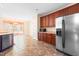 Open-concept kitchen with stainless steel refrigerator and wooden cabinets at 1175 Faulkner Town Rd, Henderson, NC 27537