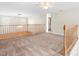 Upstairs loft area featuring neutral carpet, a ceiling fan, and wooden railing overlooking the living area at 1175 Faulkner Town Rd, Henderson, NC 27537