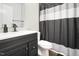Bathroom with black and white shower curtain, modern faucet, and sleek vanity at 1287 Schaub Dr # J, Raleigh, NC 27606