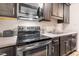Close up of stainless steel oven, range, microwave, sink, cabinets, and countertops in the kitchen at 1287 Schaub Dr # J, Raleigh, NC 27606