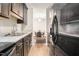 Galley kitchen with stainless steel refrigerator, sink, and views of the dining area at 1287 Schaub Dr # J, Raleigh, NC 27606