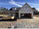 Exterior view of a new home under construction, featuring a two-car garage and a well-lit front at 147 Tuskeegee Dr, Smithfield, NC 27577