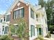 Exterior view of a condo featuring brick and siding, green shutters, and a small balcony at 1522 Kudrow Ln, Morrisville, NC 27560