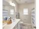Bright bathroom featuring a double sink vanity, tub-shower combo, and gray marble flooring at 1712 Red Roses Ave, Durham, NC 27703
