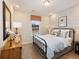 Comfortable bedroom featuring a black metal bed frame, accent wall paper, and a patterned orange window shade at 1712 Red Roses Ave, Durham, NC 27703