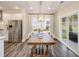 Dining area with hardwood floors, a large window with drapes, and a view of the stainless steel refrigerator at 1712 Red Roses Ave, Durham, NC 27703