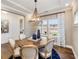 Bright dining area with a round wooden table, fabric chairs, and large windows with patterned curtains at 1712 Red Roses Ave, Durham, NC 27703