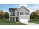 Charming two-story home with gray siding, black shutters, a manicured lawn, and attached two-car garage at 1712 Red Roses Ave, Durham, NC 27703