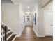 Hallway showcasing wood floors, white wainscoting, and access to the stairs at 1712 Red Roses Ave, Durham, NC 27703