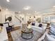 Spacious living room featuring hardwood floors, white sofas, an accent wall, and seamless access to the kitchen area at 1712 Red Roses Ave, Durham, NC 27703