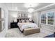 Elegant main bedroom with a chandelier, plush bedding, and a large window at 1800 Red Roses Ave, Durham, NC 27703