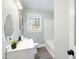 Well-lit bathroom featuring a bathtub, window, oval mirror, and modern vanity at 2204 Guess Rd, Durham, NC 27705