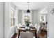 Dining room with a dining table set for six, bright windows, and an open view to the living area at 2204 Guess Rd, Durham, NC 27705