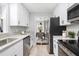 Galley kitchen with stainless steel appliances, granite countertops, and ample white cabinetry at 2204 Guess Rd, Durham, NC 27705