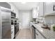Bright kitchen with white cabinets, stainless steel appliances, granite countertops, and a black faucet at 2204 Guess Rd, Durham, NC 27705