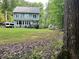 Spacious back yard features a greenhouse, lush grass, mature trees, and an area for seating at 2209 Woodnell Dr, Raleigh, NC 27603
